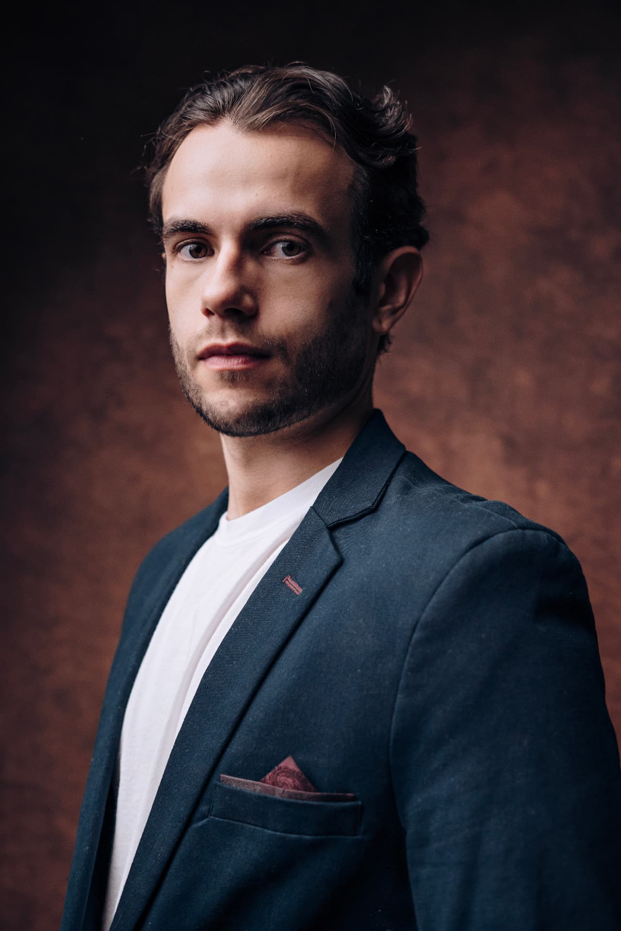 Retrato editorial de Lucian Rabello com blazer azul e lenço no bolso
